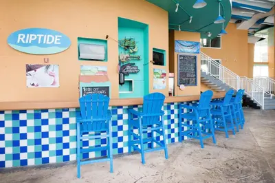 a bar with blue chairs in a restaurant at Splash 1803E in Panama City Beach