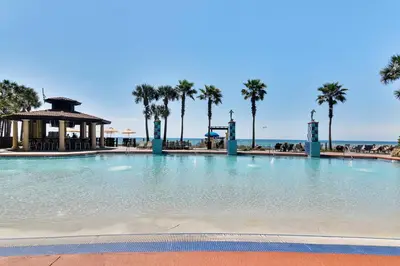 a large swimming pool with palm trees and a gazebo at Shores of Panama #124 by Book That Condo in Panama City Beach