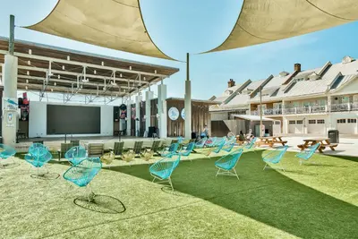 a group of chairs sitting on the grass in front of a building at Prominence on 30A Rentals by Panhandle Getaways in Watersound Beach