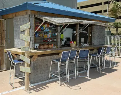 a bar with blue stools in front of a building at Tidewater 1102 in Panama City Beach