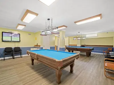 a billiard room with two pool tables and chairs at Regency Towers 505 in Panama City Beach