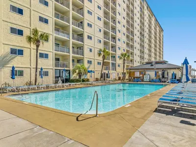 a swimming pool in front of a large apartment building at Regency Towers 505 in Panama City Beach