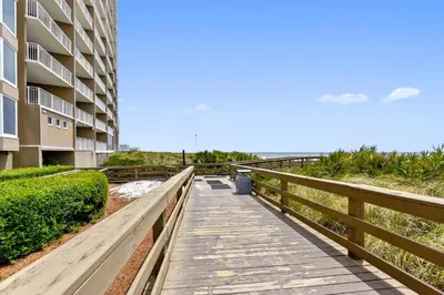 a boardwalk leading to the beach next to a building at Emerald Beach #1330 by Book That Condo in Panama City Beach