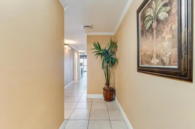a hallway with a painting on the wall and a plant at Calypso Resort Beachfront Condo in Panama City Beach