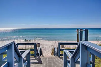 a blue boardwalk to the beach with the ocean at Panama City Beach Condo with Free Beach Service! in Panama City Beach
