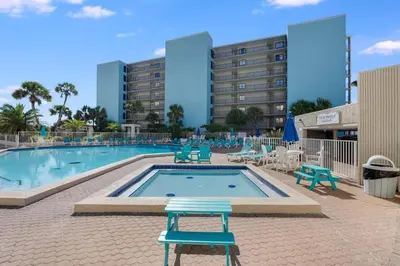 a swimming pool with blue chairs and a hotel at Top Of The Gulf 111 in Panama City Beach