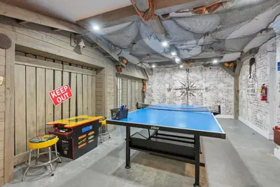 a ping pong table in a garage with a sign at Top Of The Gulf 111 in Panama City Beach