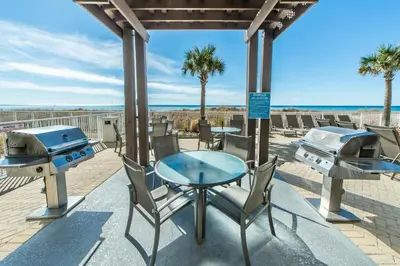 a patio with a table and two bbq and grill at Ocean Villa 1101 in Panama City Beach
