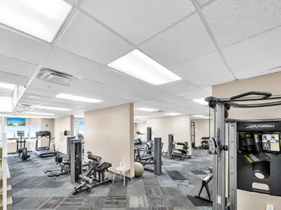 a gym with treadmills and machines in a room at Tidewater 1810 in Panama City Beach