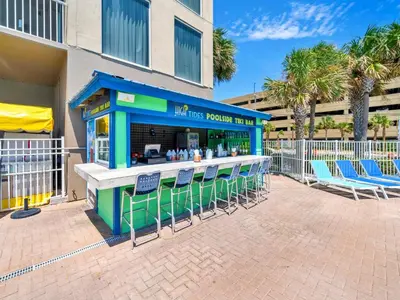 a bar with chairs in front of a building at Tidewater 1810 in Panama City Beach