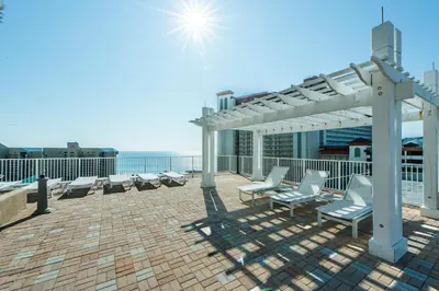 a patio with chairs and a pergola on a roof at Laketown Wharf 1626 in Panama City Beach