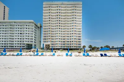 a group of beach chairs and umbrellas on the beach at Grandview East 404 in Panama City Beach