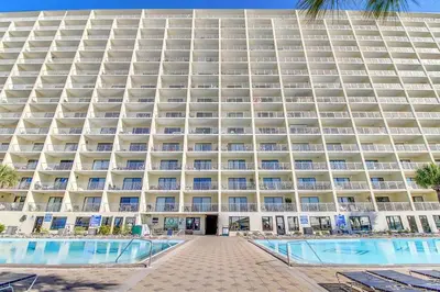 a large building with a pool in front of it at The Summit 928 in Panama City Beach