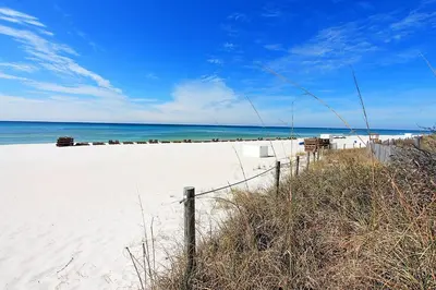 a sandy beach with a fence and the ocean at The Summit 928 in Panama City Beach