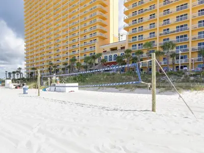 a volley ball net on the beach in front of a hotel at Calypso Beach Resort & Towers by Panhandle Getaways in Panama City Beach