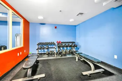 a gym with blue walls and rows of weights at Shores of Panama 1313 in Panama City Beach