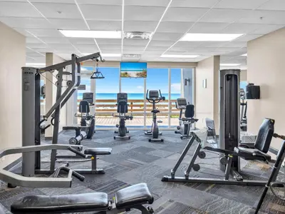 a gym with cardio equipment and a view of the ocean at Tidewater 607 in Panama City Beach