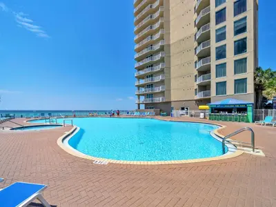a large swimming pool next to a tall building at Tidewater 901 in Panama City Beach
