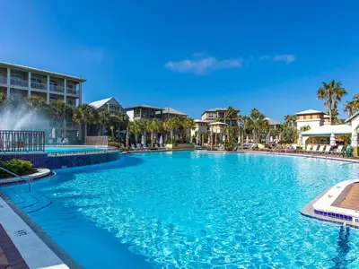 a large swimming pool at a resort with palm trees at Casa Migos in Rosemary Beach
