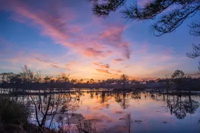 a sunset over a lake with a rainbow in the sky at Nautical Watch A-11 in Panama City Beach