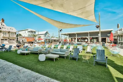 a group of chairs and tables on the grass at Prominence 30A - Lucky Old Sun in Panama City Beach