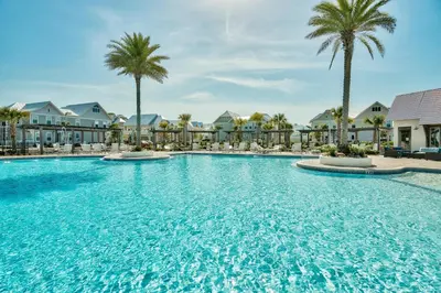 a large swimming pool with palm trees and condos at Prominence 30A - Holiday House in Watersound Beach