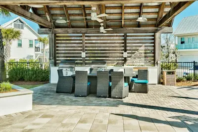 an outdoor patio with a table and chairs at Sea Haven At Prominence in Watersound Beach