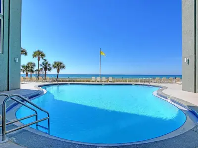 a large blue swimming pool with the beach in the background at Long Beach Resort Tower I #506 in Panama City Beach