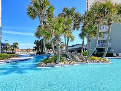 a swimming pool with palm trees in a resort at Long Beach Resort Tower I #506 in Panama City Beach