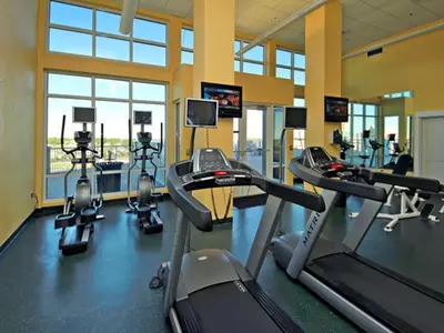 a gym with treadmills and cardio machines in a room at Grand Panama Beach Resort - The Grand #1304 in Panama City Beach