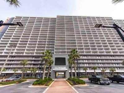 a large building with palm trees in front of it at Laketown Wharf 1907 in Panama City Beach