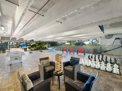 a large room with couches and a ping pong table at Emerald Beach #1927 in Panama City Beach