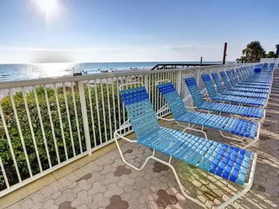 a row of blue chairs sitting next to the beach at Majestic Beach Towers I #1703 in Panama City Beach