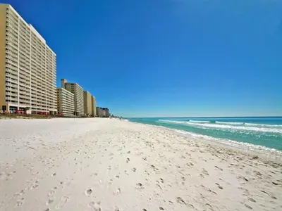 a white beach with buildings and the ocean at Majestic Beach Towers I #1311 in Panama City Beach
