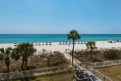 a view of a beach with palm trees and umbrellas at Long Beach Resort 1-1203 in Panama City Beach