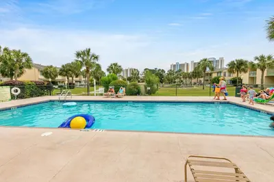 a swimming pool at a resort with people walking around it at Gulf Highlands 220 in Panama City Beach