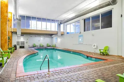 a large swimming pool in a building with green chairs at Shores of Panama 1617 in Panama City Beach