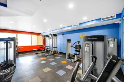 a gym with cardio equipment and a blue wall at Shores of Panama 1617 in Panama City Beach