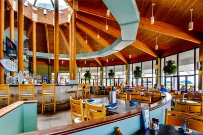 a restaurant with a dining area with tables and chairs at Edgewater Golf Villa 2010 in Panama City Beach