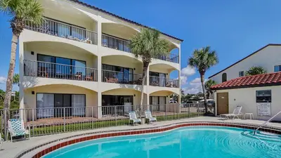 a hotel with a swimming pool in front of a building at Palms C14 in Santa Rosa Beach