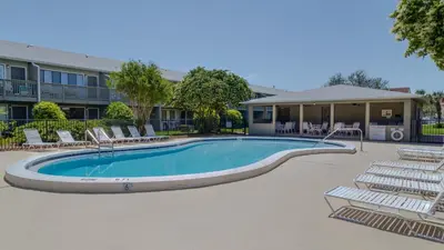 a swimming pool with lounge chairs in front of a building at Hidden Beach 228 in Santa Rosa Beach