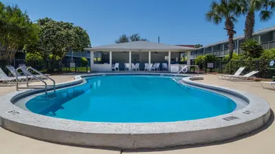 a large swimming pool with chairs and a building at Hidden Beach 240 in Santa Rosa Beach