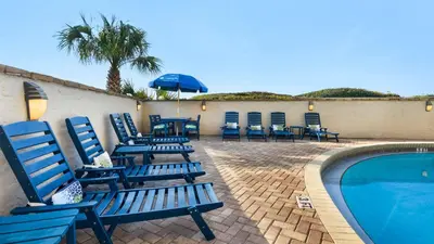 a group of blue chairs sitting next to a swimming pool at Beachcrest 1201 in Santa Rosa Beach