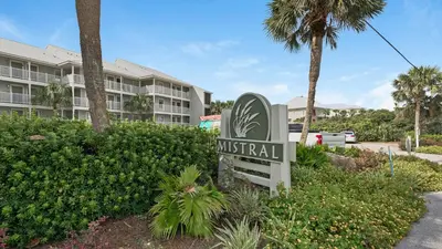 a sign in front of a resort with a building at Mistral 10 in Seacrest