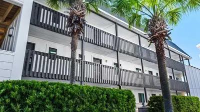 two palm trees in front of a building at Beachside Condo 11 in Santa Rosa Beach