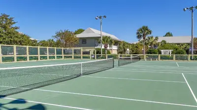 a tennis court with a net in front of a house at Beachwood Villas 3A in Santa Rosa Beach