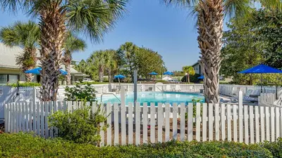a white fence with palm trees and a pool at Beachwood Villas 3H in Santa Rosa Beach