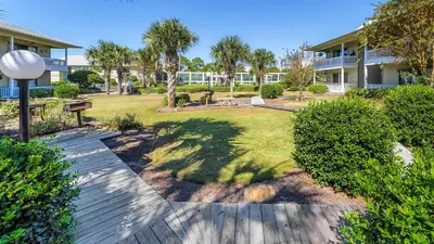 a walkway through a yard with trees and a building at Beachwood Villas 7F in Santa Rosa Beach