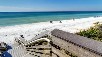a bench on the beach with the ocean in the background at Beachwood Villas 9B in Santa Rosa Beach