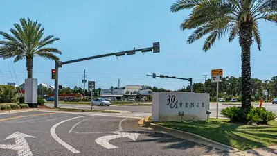 an intersection with a traffic light and a sign that says expensive at Beach Daze in Panama City Beach